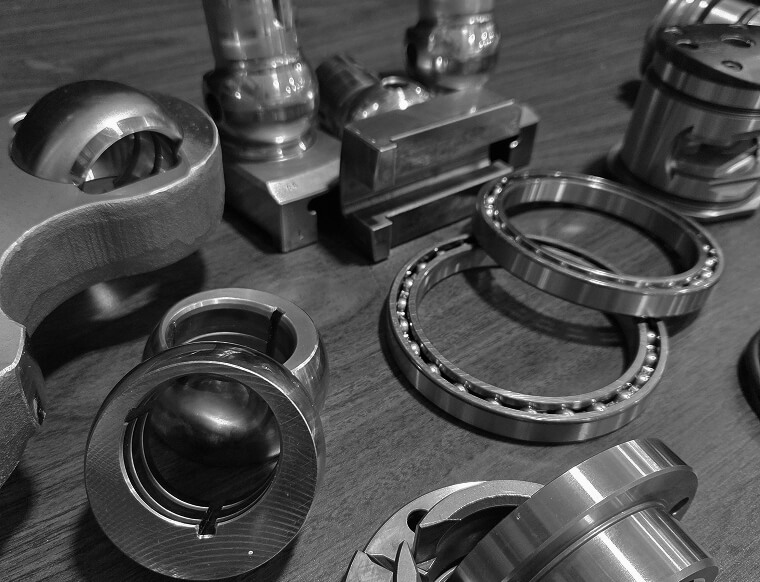 Hydraulic chuck replacement parts including ball bearings, jaw nuts, collet components, and precision machined rings laid out for service or rebuild